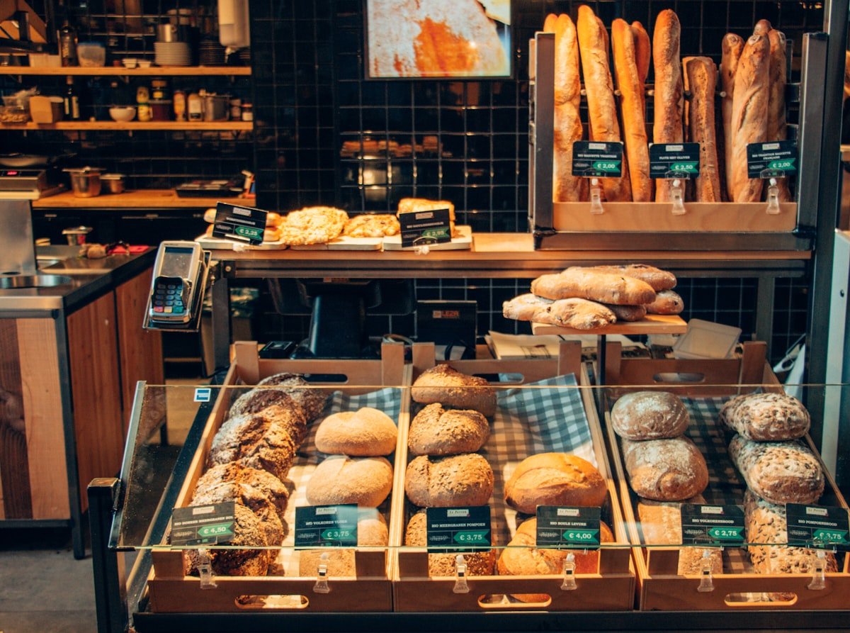 Warme bakkerijtoonbank vol vers brood en gebak in zacht ochtendlicht